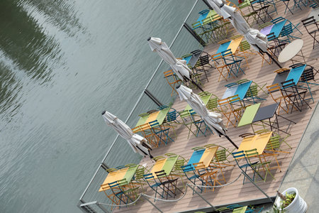 small tables and chairs in the alfresco restaurant by the water without peopleの写真素材