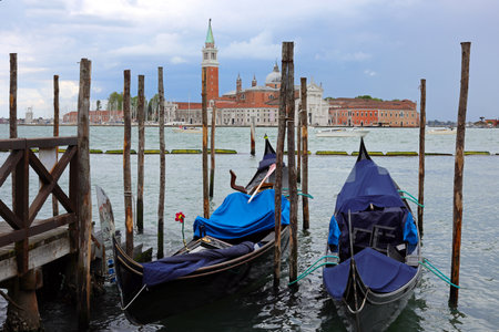 moored gondolas the typical boats in venetian Lagoon in VENICE In Northern Italy and Church of St.Georgeの写真素材
