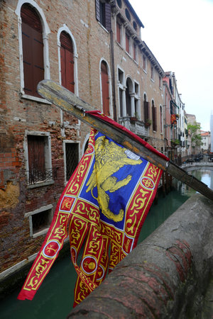 Big flag of Veneto Region in Venice Island in Northern Italy with winged Lyon and water of navigable canalの写真素材