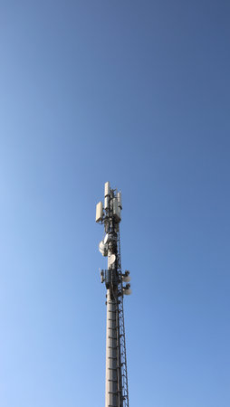 high antenna of the repeater of the cellular network and wifi signal with many devices of reception transmission and amplification of the signals and blue skyの写真素材
