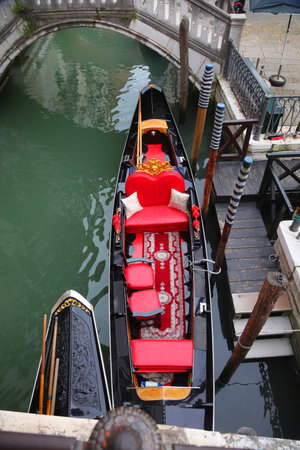 gondola boat deluxe with red seats in the navigable canal in Venice Island in Northern Italyの写真素材