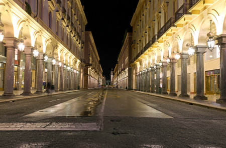 Night view of the street called VIA ROMA in Turin City in Northern Italy with many arcades and large shop windowsの写真素材