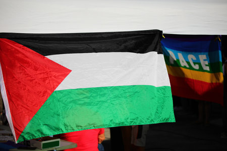 Palestinian flag under a gazebo during a protest and the flag with text PACE that means PEACE in Italian languageの写真素材
