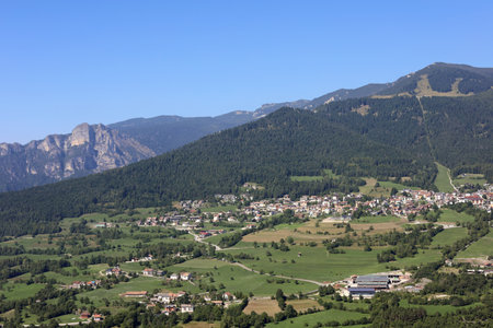 view of the FOLGARIA Village in Northern Italy in Trentino Region and mountains called ALPE CIMBRA with green treesの写真素材