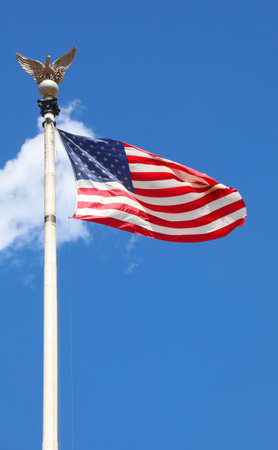 American flag a powerful symbol of freedom and patriotism on blue sky with Bald Eagle or eagle finialの写真素材