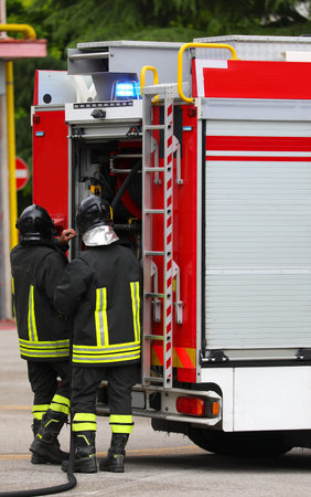 firefighters taking equipment from their fire truck during a city emergency