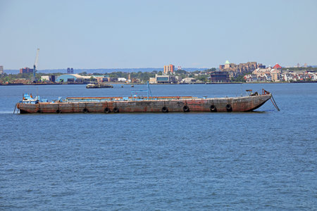 long large industrial barge for transporting goods sailing in the sea near the port