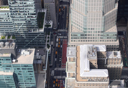 top down aerial view of a busy street with buildings and cars below on the large avenue