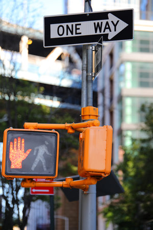 pedestrian traffic light with red hand and one way sign in new york city