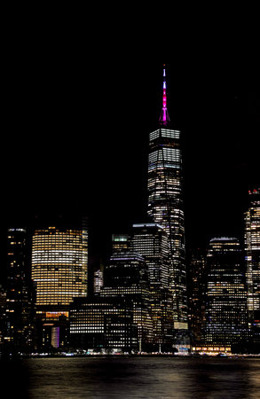 Illuminated Manhattan skyscrapers at night viewed from New Jersey in New York City USA