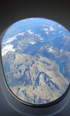 view from the airplane window and the rocky mountains below ideal as a travel concept