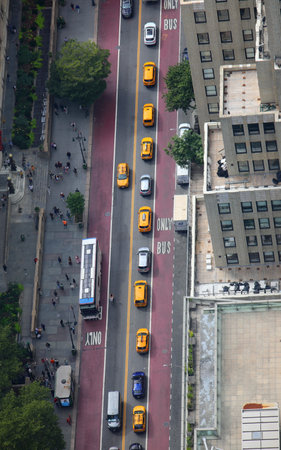 busy street with buses cars and yellow taxis seen from a high skyscraper in new york city manhattan...