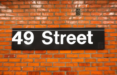 subway station sign for forty ninth street in new york and the old red brick wallの写真素材