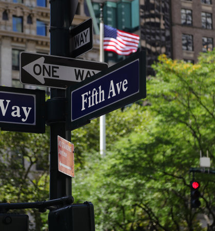new york City street intersection at fifth avenue and the usa flag in the backgroundの写真素材