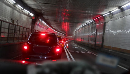inside the lincoln tunnel in new york with many cars lined up in traffic and red taillightsの写真素材