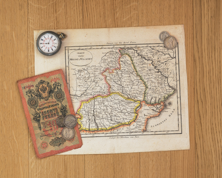 old map on table with old coins of distant and exotic states. memories of unforgettable adventures.のeditorial素材