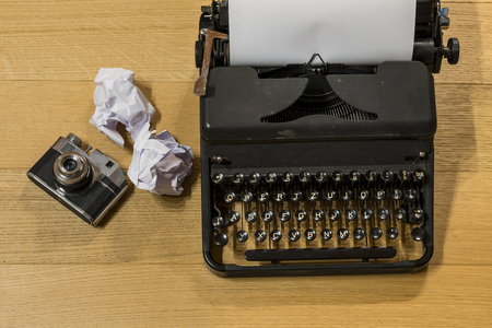 photo of a desk with a typewriter and a camera. symbols of an old explorer who is writing the adventures of his last journey.の写真素材