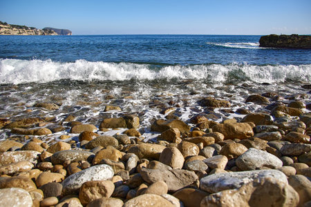 Polished stones and rocks at the beach on the Mediterranen Sea in Spain on a sunny dayの写真素材