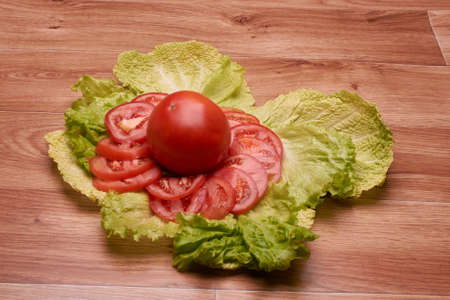 sliced, red, tasty vegetables lie on a large tableの写真素材