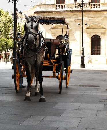 An old cart with a yellow wheels pulled by a horse.のeditorial素材