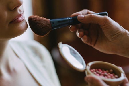Make up the makeup on the bride's face with a brushの写真素材