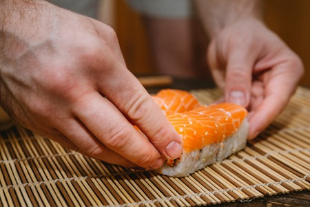 Man rolling sushi closeup photoの写真素材