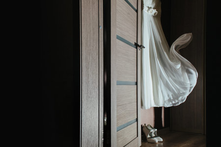 hanging on the wardrobe wedding dress is developing under the gust of wind, at the bottom are white...