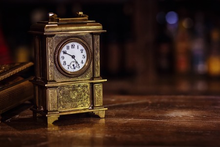 interior of a house in which antique clocks stand on a wooden tableの写真素材