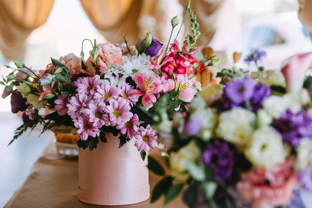 A steel bucket of flowers is on the table in a cafe. colorful bouquet with flowers and green leaves...