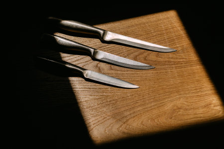 set of kitchen knives on a wooden cutting boardの写真素材