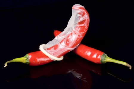 Passion under control - hot peppers and latex condomの写真素材