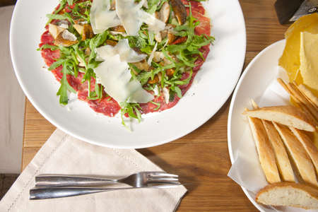 Italian carpaccio on resraurant table, with fork and knifeの写真素材