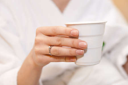 Woman with coffee, focus is on ring, shallow dofの写真素材