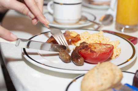 Typical hotel breakfast - fried bacon, egg and stuffed tomatoの写真素材