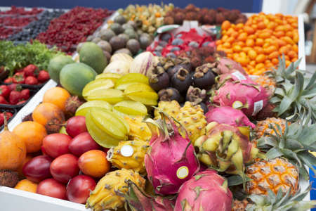 Various trropical fruits and berries lying on market stallの写真素材