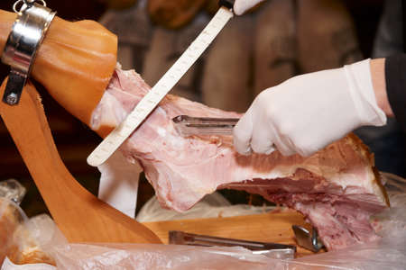 Waiter is slicing jamon (prosciutto)の写真素材
