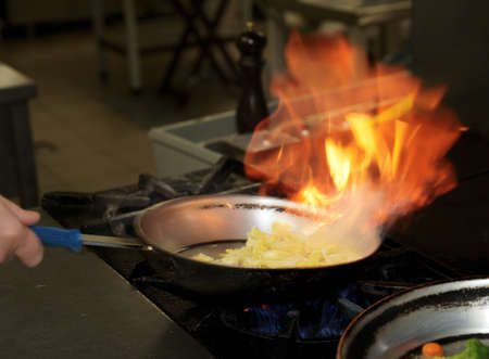 Chef is making flambe sauce on restaurant kitchenの写真素材