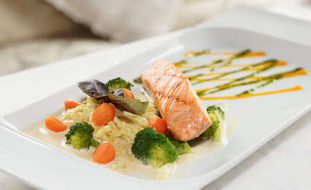 Grilled salmon with vegetables on restaurant tableの写真素材