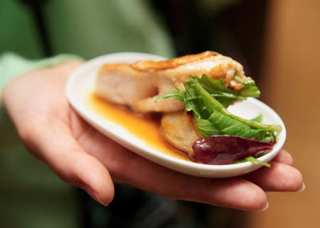 Woman offering small snack on banquetの写真素材