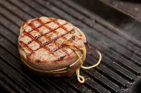 Tenderloin steak with bacon on grill panの写真素材