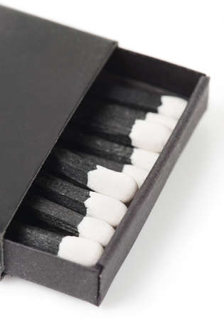 Black matches on white surface, macro shotの写真素材
