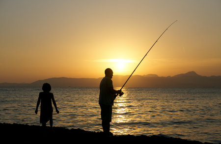 Man and a little girl fishing in the evening, Mallorca, Spainの写真素材