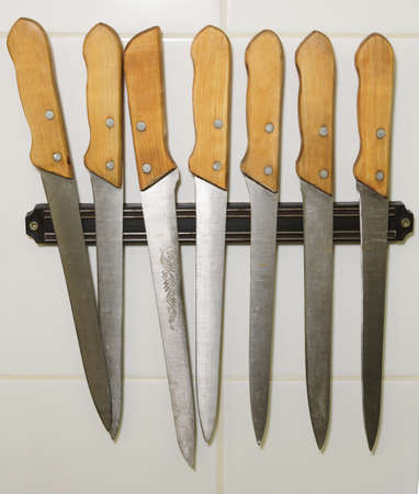 Plain professional knives on magnet holder in a restaurantの写真素材