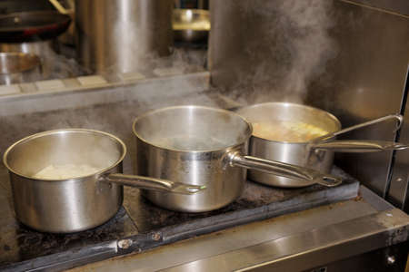 Pots with boiling food on electric rangeの写真素材