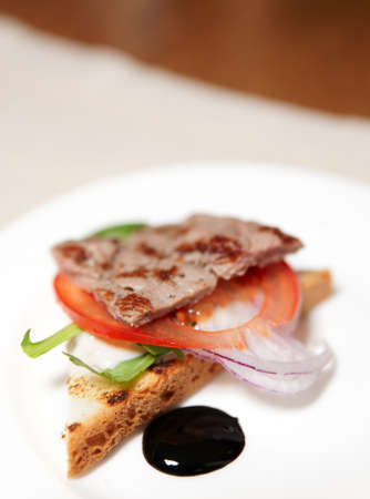 Sandwich with grilled meat, onion, tomato and balsamic vinegarの写真素材