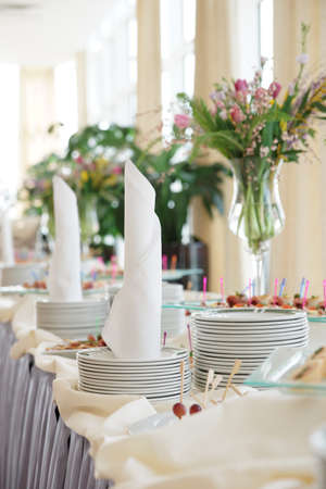 Table with dishware and tasty food waiting for guestsの写真素材