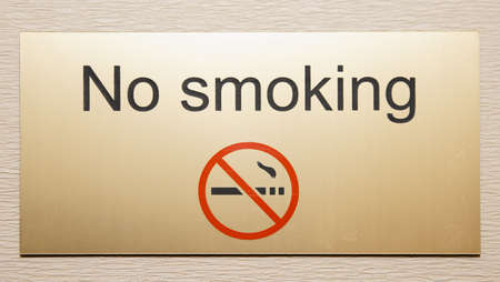 Shiny brass plate restricting smoking on hotel floor の写真素材