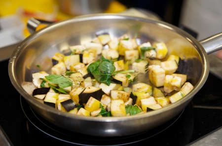 Eggplant being cooked in oven with basilの写真素材