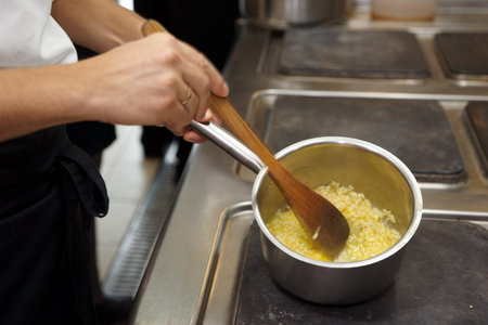 Chef is cooking risotto on professional kitchen