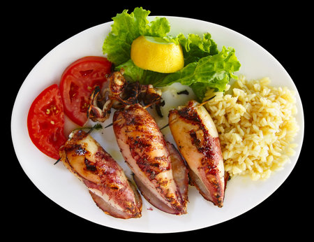 Grilled stuffed squids with rice isolated on black background